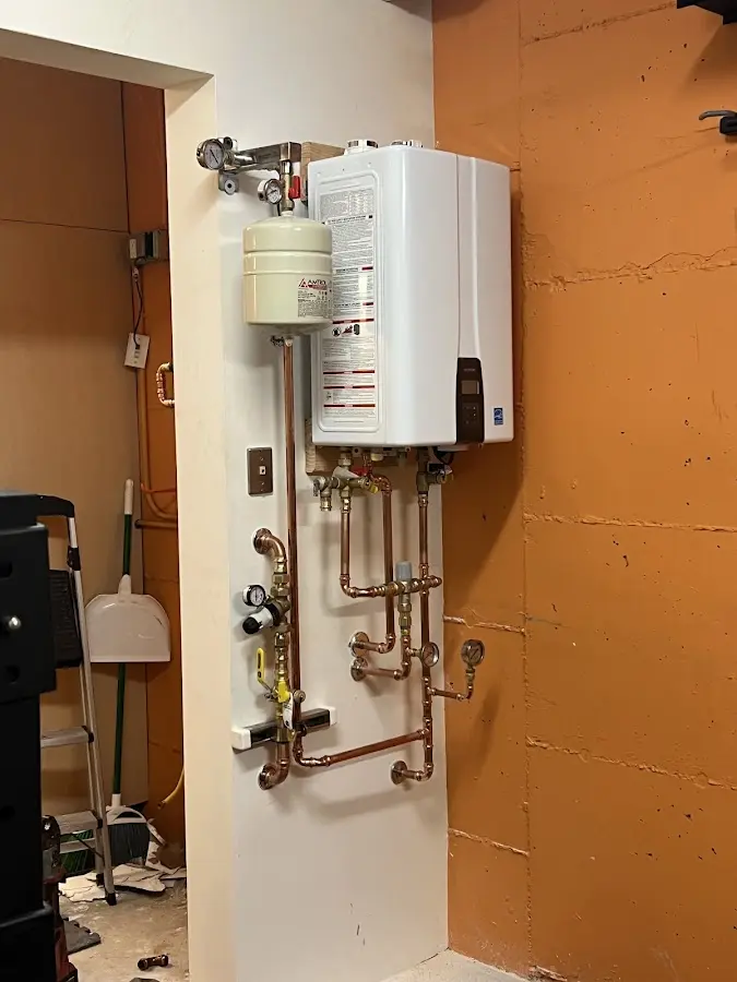 Plumbing technician inspecting water heater connections in Port Isabel